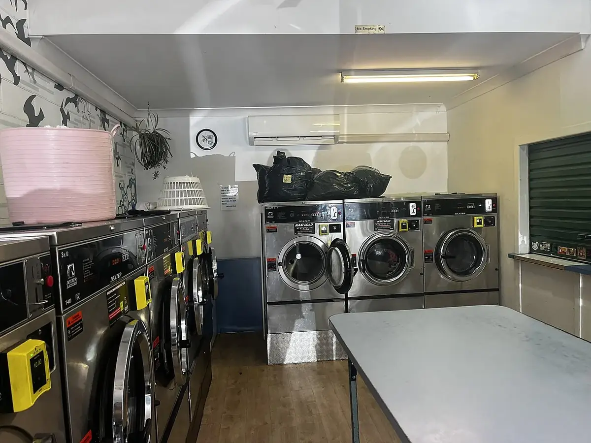 Small laundromat with rows of stainless front-load machines